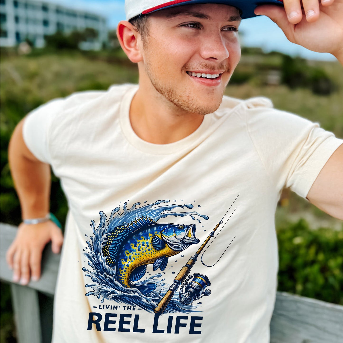 Funny Fisherman Shirt – Livin' The Reel Life Fishing Pun Tee – Humor Gift for Anglers – Natural – Up To 5XL