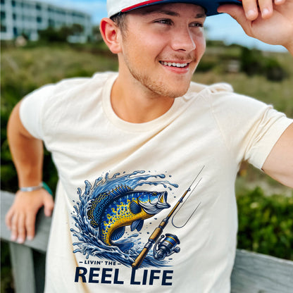 Funny Fisherman Shirt – Livin' The Reel Life Fishing Pun Tee – Humor Gift for Anglers – Natural – Up To 5XL