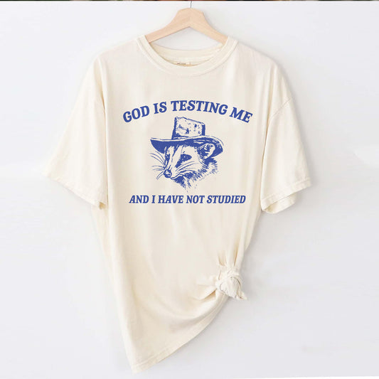 Funny Faith Shirt – God Is Testing Me and I Have Not Studied – Raccoon Meme Christian Tee – Natural – Up To 5XL